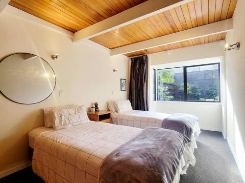 Duas camas num quarto com uma janela em Hagley Park Townhouse em Christchurch