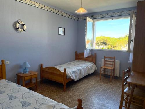 une chambre avec deux lits et une fenêtre dans l'établissement Appartement calme à Saint-Jean-de-Monts, 150m plage, balcon exposé Sud/Ouest, parking privé - FR-1-323-305, à Saint-Jean-de-Monts