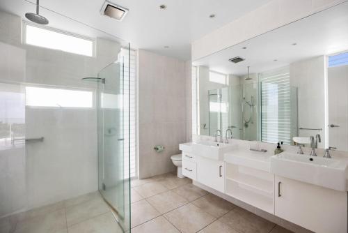 a white bathroom with two sinks and a shower at 7 on Pelican Street Peregeian Beach in Peregian Beach