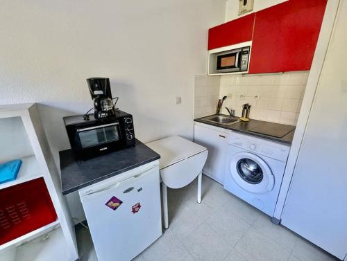 a small kitchen with a washing machine and a microwave at Pratique, Proche Gare & Petit Prix avec Parking in Grenoble