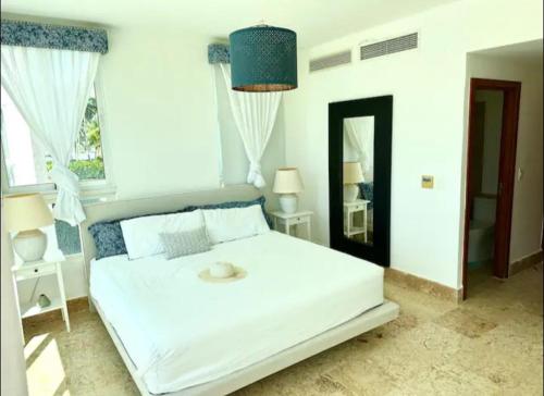 una camera da letto con un grande letto bianco con una grande finestra di Playa Nueva Romana Royal Vip a San Pedro de Macorís