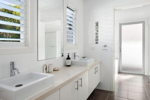 ein weißes Badezimmer mit 2 Waschbecken und einem Spiegel in der Unterkunft 75 Lorikeet Drive Peregian Beach in Peregian Beach
