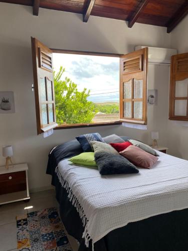 Bett mit Kissen in einem Zimmer mit Fenster in der Unterkunft KARIFUNA-II in Baie Mahault