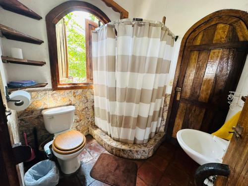 a bathroom with a shower and a toilet and a sink at Casa Villa Pesca in Monterrico