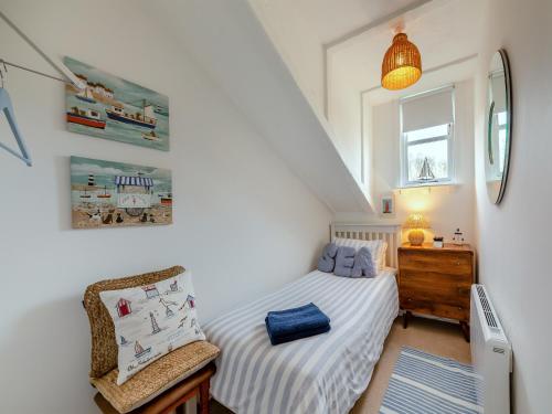 Ash Cottage في كراستر: غرفة نوم صغيرة بها سرير وكرسي