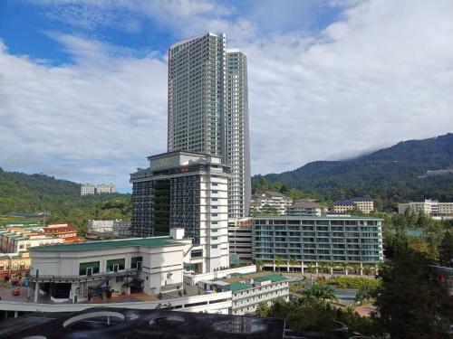 a tall skyscraper in the middle of a city at Windmill Upon Hills Genting Highland by Sweet Memory in Genting Highlands