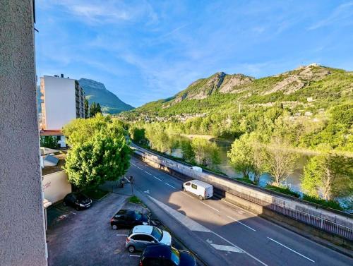uma vista para uma estrada com carros estacionados ao lado de um rio em Pratique, Proche Gare & Petit Prix avec Parking em Grenoble