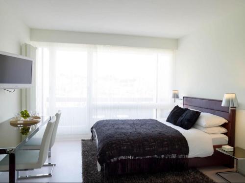 a bedroom with a bed and a large window at VISIONAPARTMENTS Rue Caroline - contactless check-in in Lausanne