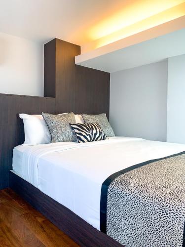 a bedroom with a bed with white sheets and pillows at Heritage Collection on Seah - Mobile App Check-In in Singapore