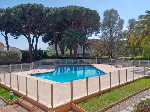 une piscine entourée d'une clôture dans l'établissement Studio avec piscine, climatisation et parking à 100 m du centre et plage - Sainte-Maxime - FR-1-780-49, à Sainte-Maxime