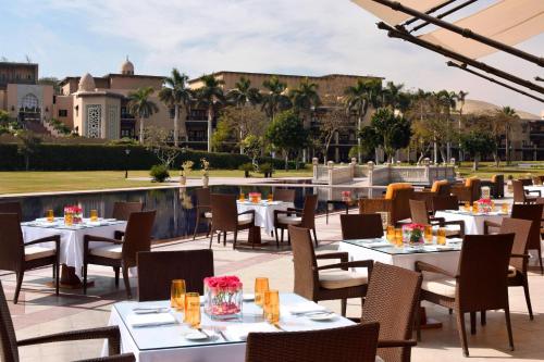 a restaurant with tables and chairs on a patio at Marriott Mena House, Cairo in Cairo