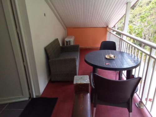 een klein balkon met een tafel en stoelen erop bij PAPILLON 2 in Rivière-Pilote