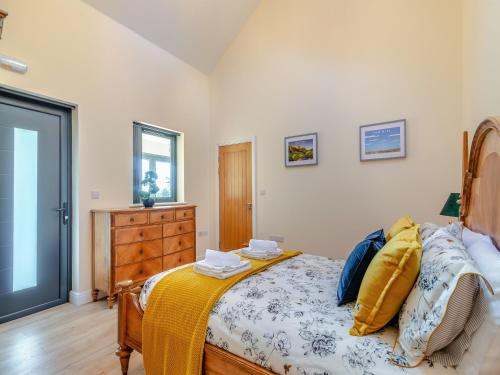 a bedroom with a bed and a dresser and a window at The Cedars Cottage 2 - Uk46778 in Cloughton