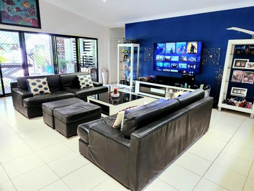 un soggiorno con mobili in pelle nera e TV a schermo piatto di ISLAND ROOM on Magnetic Island a Horseshoe Bay