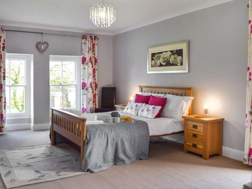 a bedroom with a bed with pink and white pillows at Gymmin House in Pendine