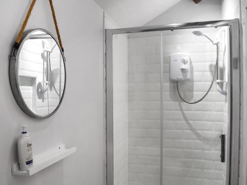a bathroom with a shower and a mirror at Dove House 