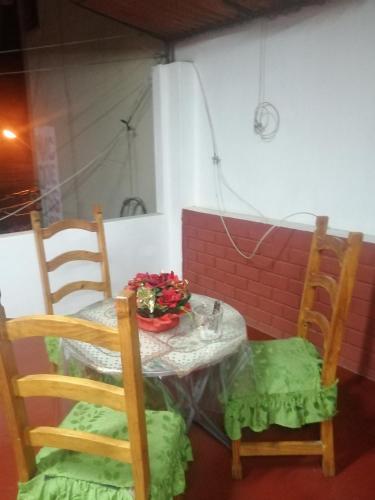 einen Tisch und Stühle mit Blumen darüber in der Unterkunft MARCAPURA in Nazca