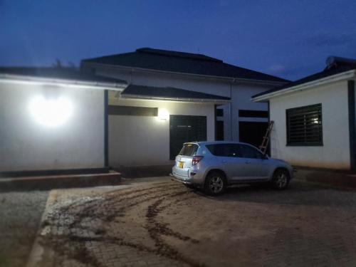 a car parked in front of a house at night at Grand Grove in Jinja