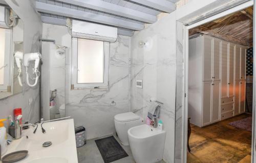 Baño blanco con aseo y lavamanos en Lovely Home In Santa Croce Camerina With Kitchen, en Santa Croce Camerina