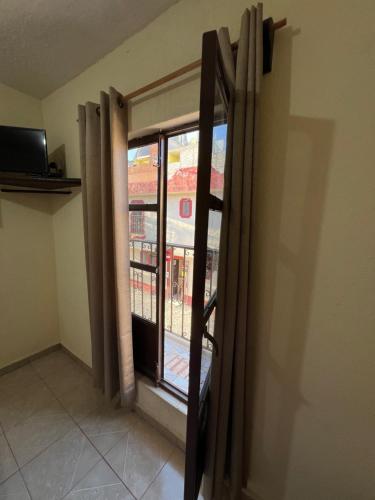 eine offene Tür zu einem Fenster in einem Zimmer in der Unterkunft Hotel Casa De Los Abuelos in Bernal