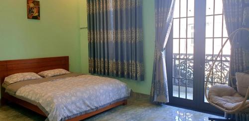 - une chambre avec un lit et une grande fenêtre dans l'établissement Romantic house with garden in Bien Hoa, à Bùi Tiếng