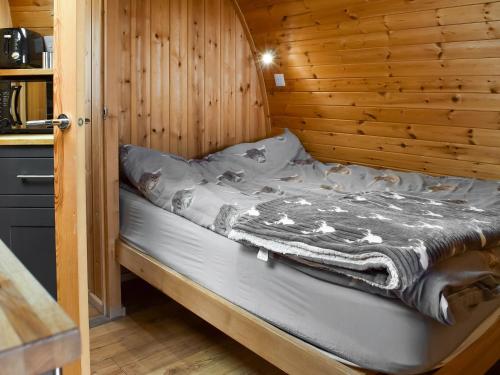 a bed in a room with a wooden wall at Withy Bottom-uk1393 in Corney
