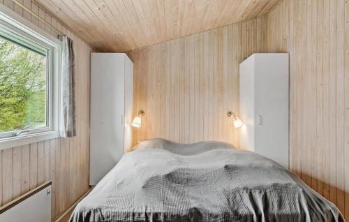 a bedroom with a bed in a wooden wall at Holiday Home Filosofstræde Vi in Dannemare