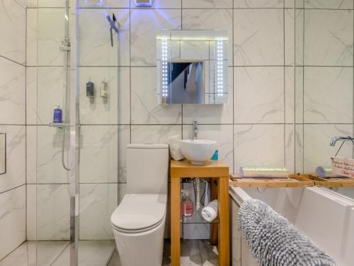 La salle de bains est pourvue de toilettes, d'un lavabo et d'une douche. dans l'établissement Country Escape At The Granary, à Copford