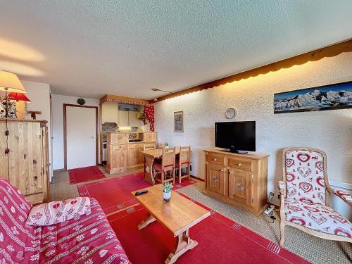 un salon avec un canapé, une table et une télévision dans l'établissement Studio cosy au centre de Combloux avec parking - FR-1-560-129, à Combloux