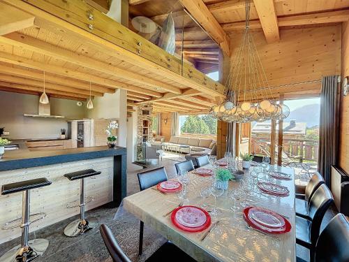 une salle à manger avec une grande table et une cuisine dans l'établissement Superbe chalet au calme avec jardin, garage et Wifi - FR-1-560-130, à Combloux