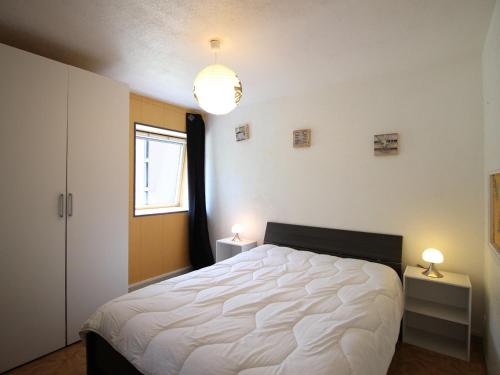 - une chambre avec un lit blanc et 2 tables avec des lampes dans l'établissement Appartement T2 au Mont-Dore, pied des pistes, parking inclus, capacité 4 pers. - FR-1-415-154, à Mont-Dore