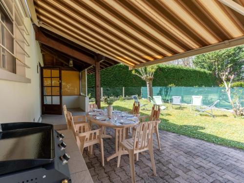 un patio avec une table, des chaises et un barbecue dans l'établissement Maison landaise rénovée, 6 pers: proche lac, plage, surf, jardin, terrasse, vélos et ménage inclus - FR-1-319-545, à Parentis-en-Born