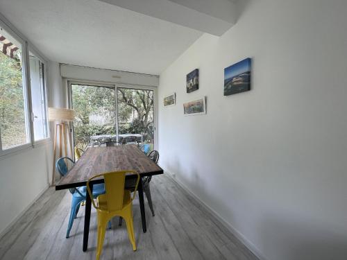 une salle à manger avec une table et des chaises et une fenêtre dans l'établissement Maison familiale à Arcachon : 3 chambres, jardin sous les pins, WIFI FIBRE, proche plage et centre - FR-1-420-145, à Arcachon