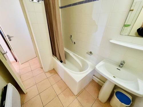 une salle de bain avec une baignoire, un lavabo et une douche dans l'établissement 2 pièces avec terrasse, piscine chauffée, proche plage et port - FR-1-723-152, au Cap d'Agde