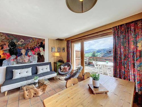 un salon avec un canapé et une table dans l'établissement Appartement Mont Blanc : 2 chambres, terrasse, parking et équipements modernes - FR-1-560-131, à Demi-Quartier