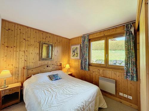 une chambre avec un lit et une fenêtre dans l'établissement Appartement Mont Blanc : 2 chambres, terrasse, parking et équipements modernes - FR-1-560-131, à Demi-Quartier