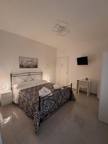a bedroom with a bed with a black and white bedspread at Rovelli House in Foggia