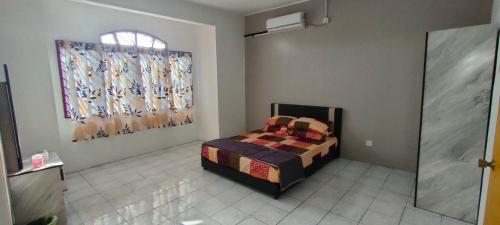 Schlafzimmer mit einem Bett und einem Fenster in der Unterkunft Homestay Atikah Bahau in Bahau