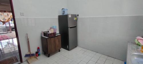 a kitchen with a refrigerator in the corner of a room at Homestay Atikah Bahau in Bahau