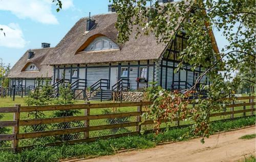 a house with a wooden fence in front of it at Pet Friendly Apartment In Sorkwity in Sorkwity