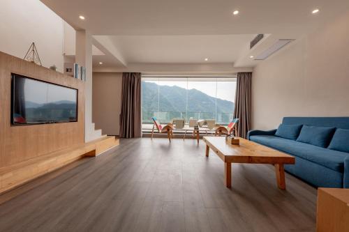 a living room with a blue couch and a tv at Avatar Mountain Resort in Zhangjiajie