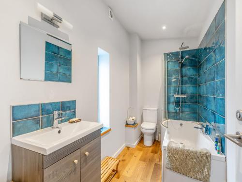 a bathroom with a sink and a tub and a toilet at Earthspring Flat in Totnes