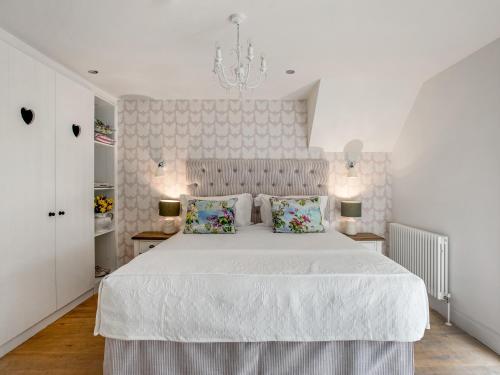 a white bedroom with a large white bed with two pillows at The Owl Nest-uk46927 in Newby Bridge