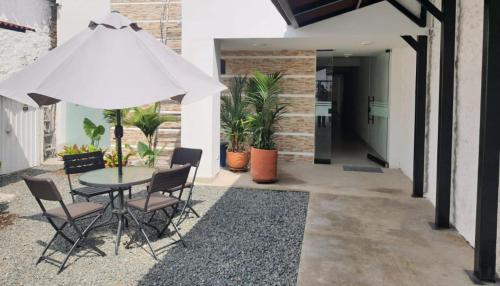 a patio with a table and chairs and an umbrella at HOTEL MELAO in Palmira