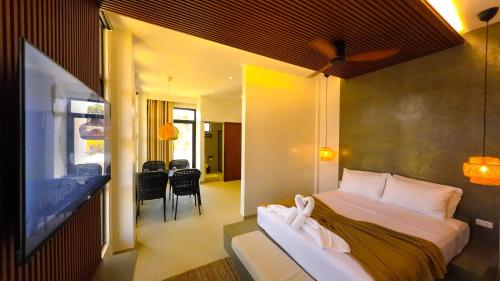 a hotel room with a bed and a flat screen tv at Go Boutique Inn in Puerto Princesa City