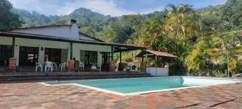uma casa com uma piscina em frente em CQ SANTA ANA em San Antonio del Tequendama