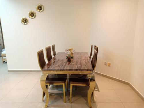 a dining room with a wooden table and chairs at 22 R3 Luxury Room in a 4-bedroom apartment with private washroom outside the room ### 22 R3 غرفة فاخرة في شقة 4 غرف نوم مع حمام خاص خارج الغرفة ### in Ajman 