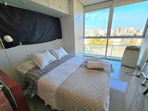 una camera da letto con un letto e una grande finestra di Fantastic spot: Studio w/parking 2 blocks to World Trade Center, 3 to beach a Montevideo