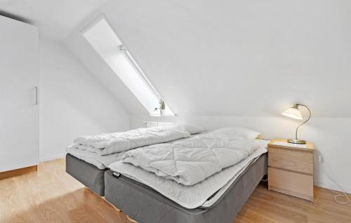 a bed in a room with a white wall at 11 Bedroom Pet Friendly Home In Rønde in Rønde