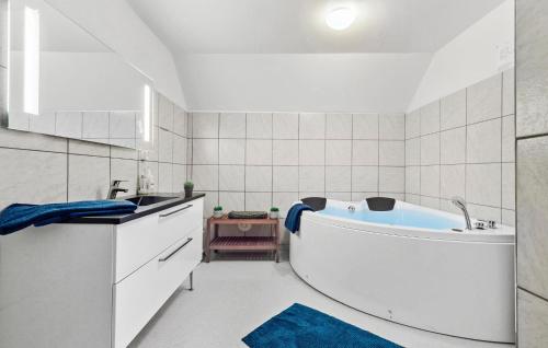 a white bathroom with a tub and a sink at 11 Bedroom Pet Friendly Home In Rønde in Rønde